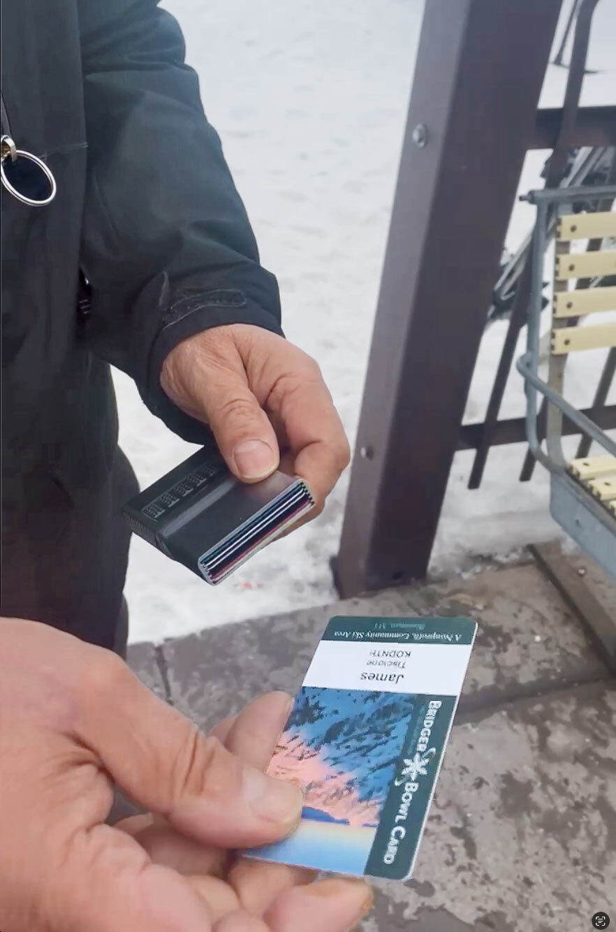 James selecting his Ski Pass and adding it below the Money Clip to be scanned by the lift operator.